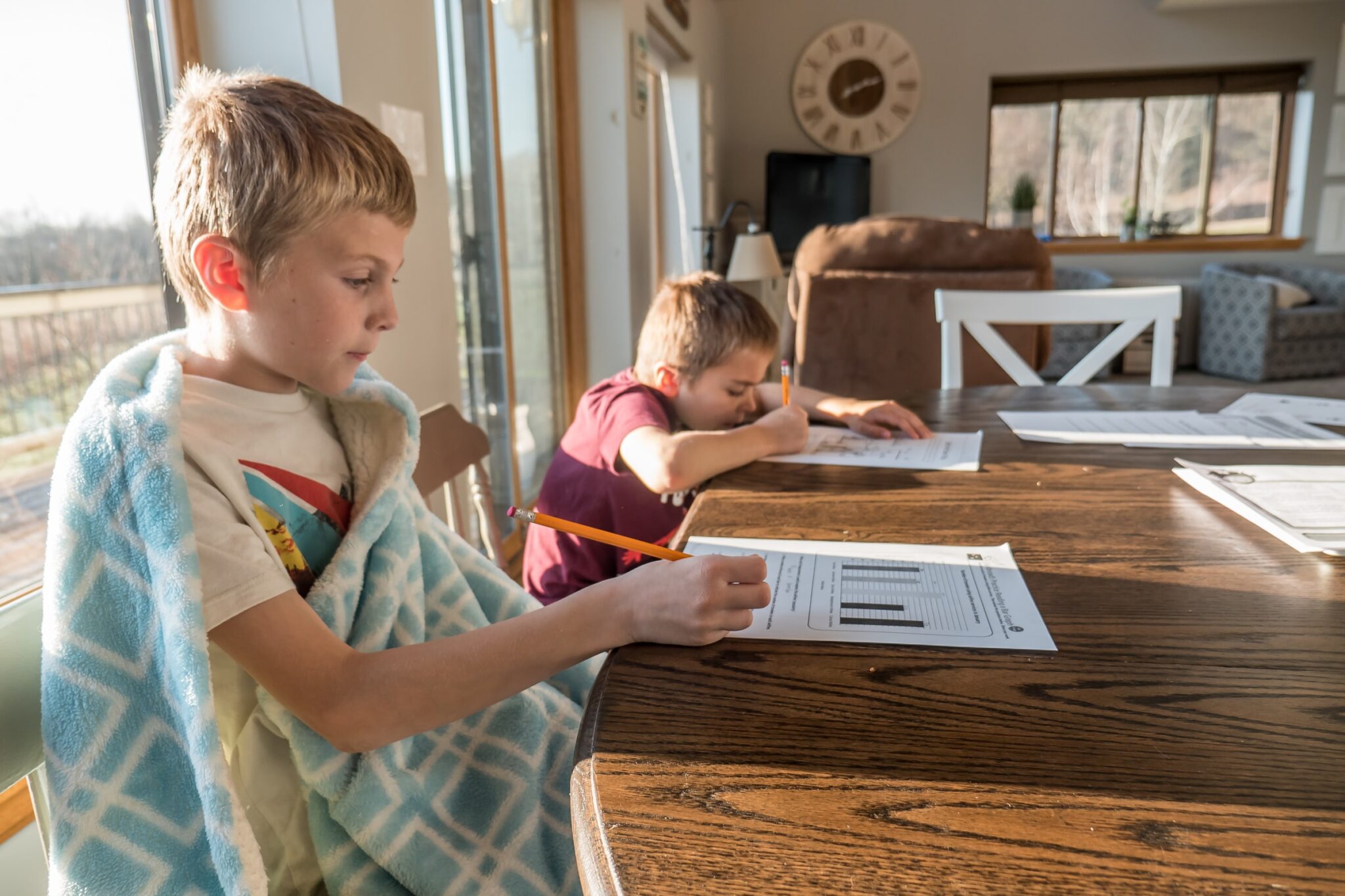 two children doing homework at table
