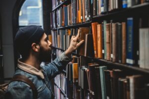 depicts person searching shelves of library